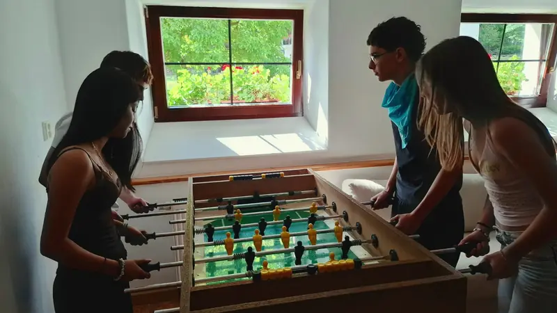 Participantes jugando al futbolín en la zona común del alojamiento