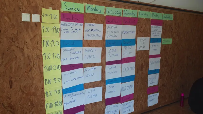 Programa de la semana en papelógrafos de colores colgado en la pared de la sala