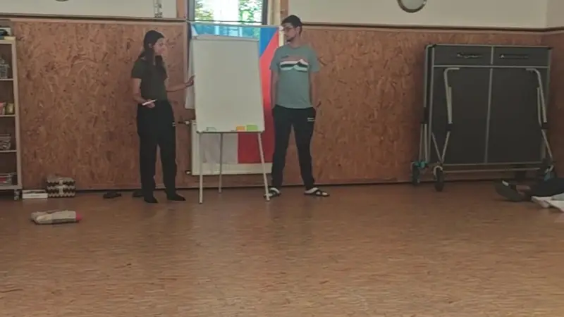 Dos facilitadores junto a un papelógrafo explicando una actividad al grupo