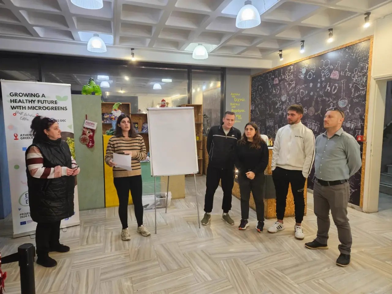 Presentación del proyecto junto al cartel «Growing a Healthy Future with Microgreens»