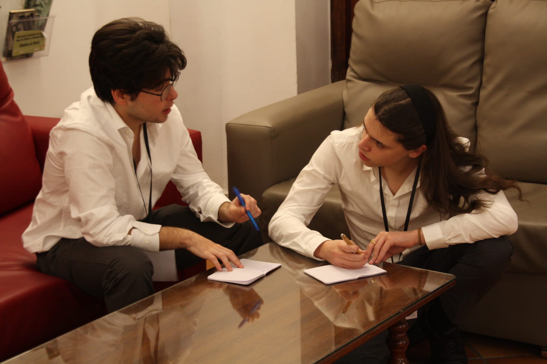Dos participantes preparando sus argumentos antes de una sesión del torneo