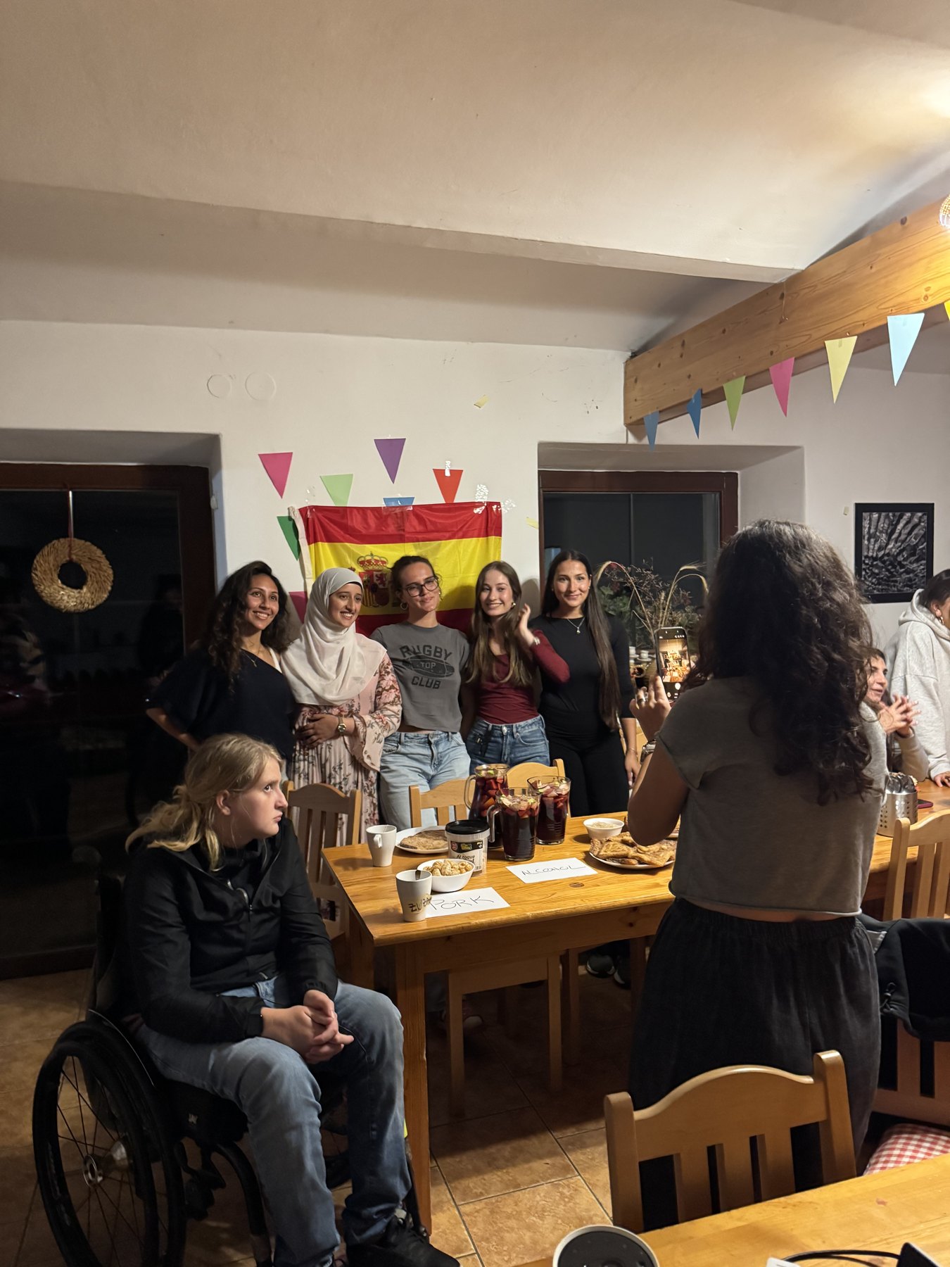 Mesa de la noche intercultural con la bandera de España al fondo