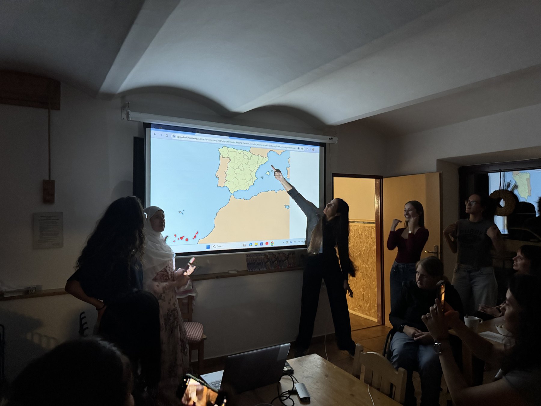 Presentación del grupo español señalando el mapa de España durante la sesión de países