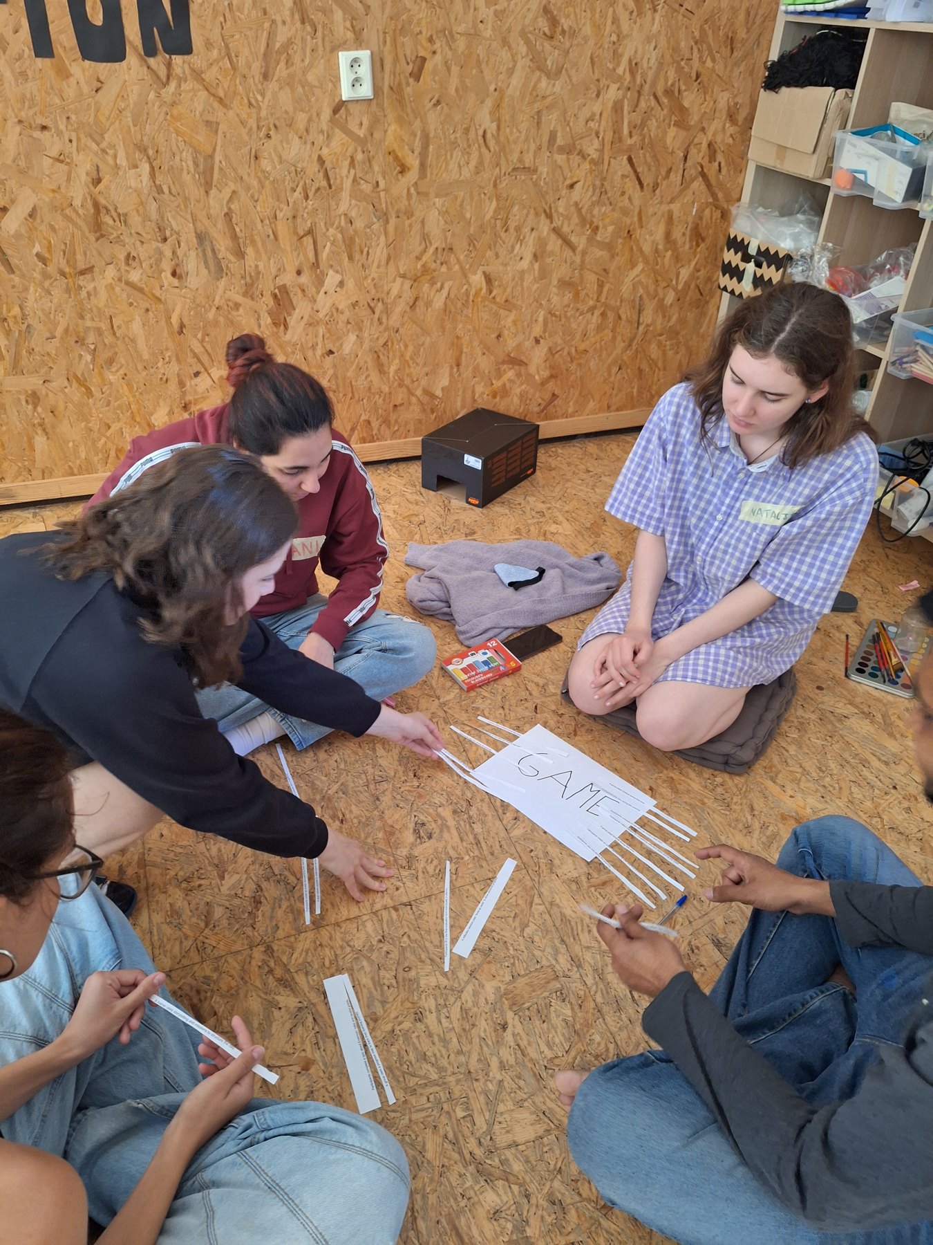 Participantes construyendo el prototipo de un juego en el suelo de la sala de trabajo