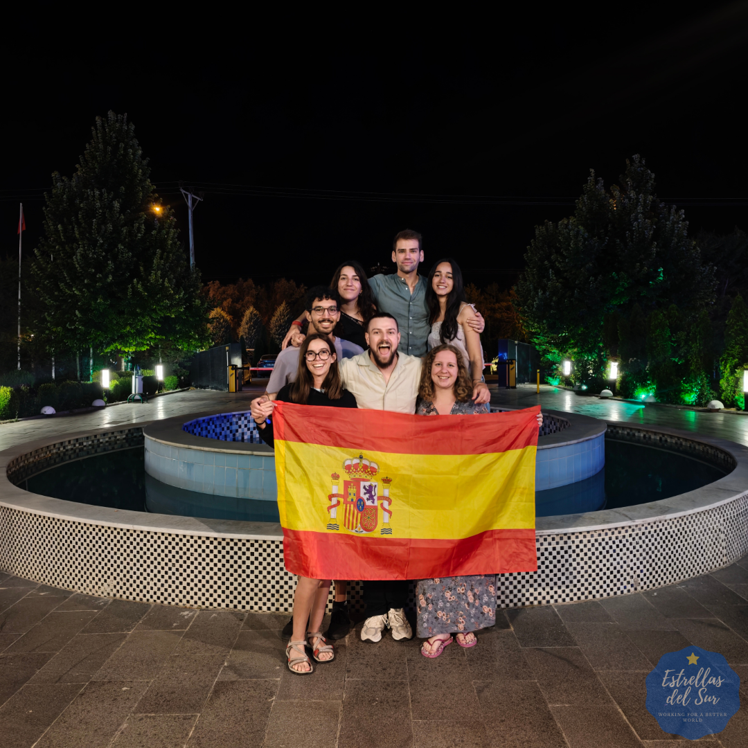 Los siete participantes de Estrellas del Sur con la bandera de España durante la velada cultural